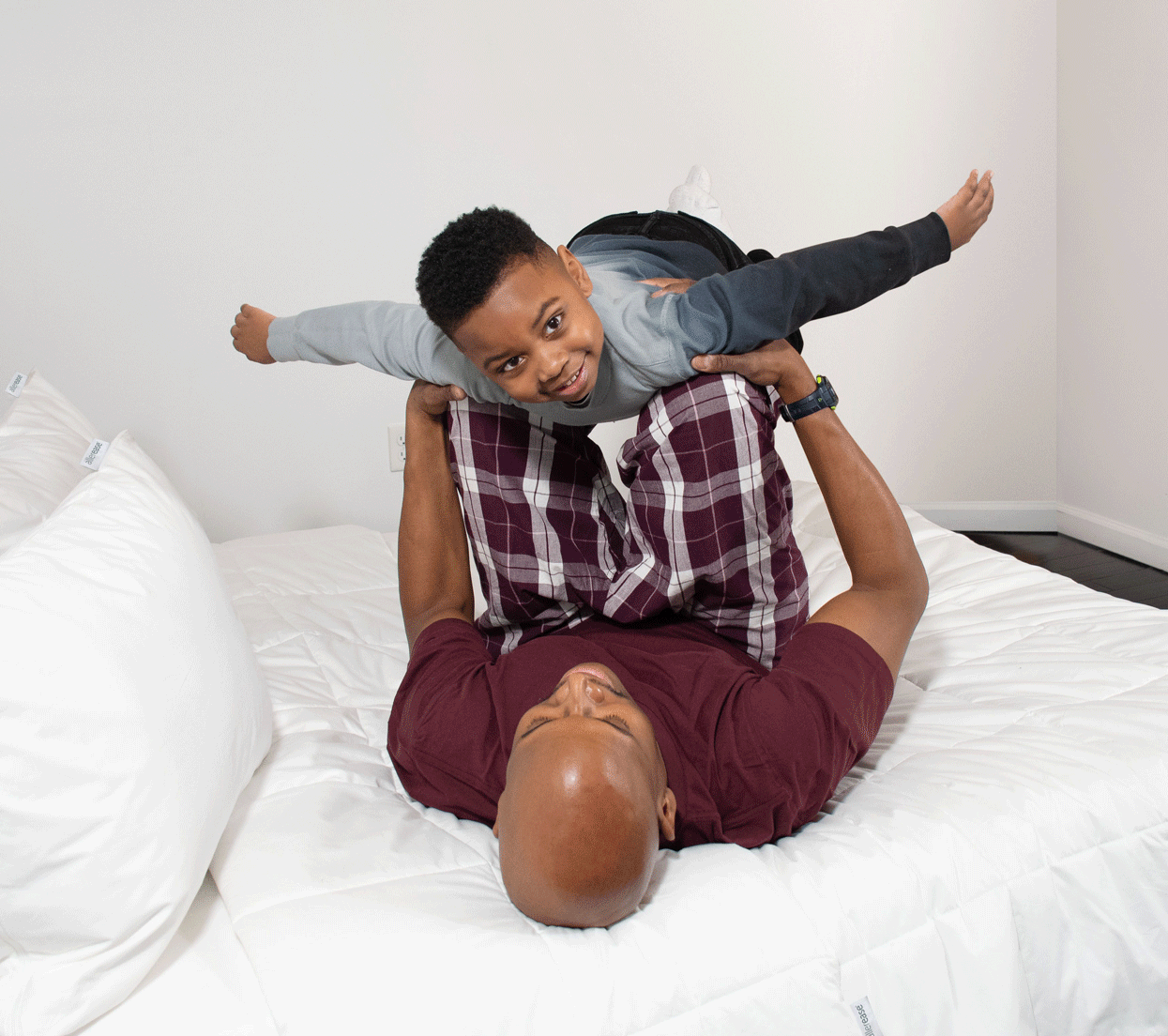 Father and son playing airplane on AllerEase bed